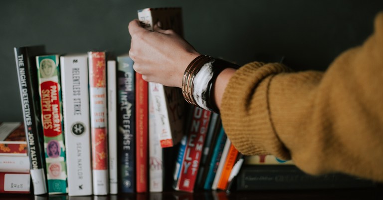 Novel Suspects Featured Image Bookshelf Hand