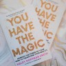 Photo of two copies of You Have the Magic laid above a white and gold marble backdrop
